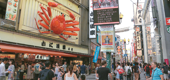 일본 입국 규제가 전면 해제되면서 일본 관광에 나서는 한인들이 급증하고 있는 것으로 나타났다. 한인들이 즐겨 찾는 오사카의 도톤보리 먹거리 골목의 홍보전광판에 한글 안내가 나오고 있다. 박낙희 기자