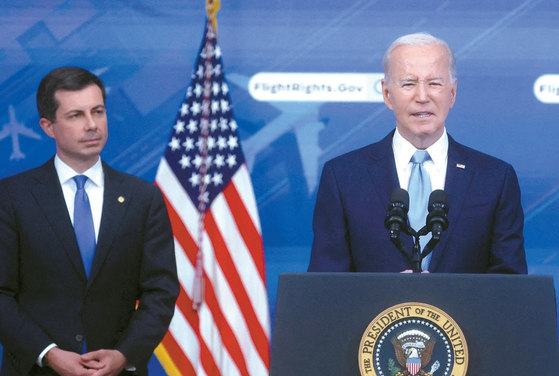 조 바이든 대통령이 8일 백악관에서 항공 승객 보호 강화를 위한 새로운 규정 제정을 발표하고 있다. 왼쪽은 피트 부이지지 교통부장관. [로이터]
