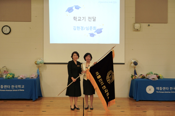 김현경 교장(오른쪽)이 심준희 신임 교장에게 한국학교 기를 전달했다.