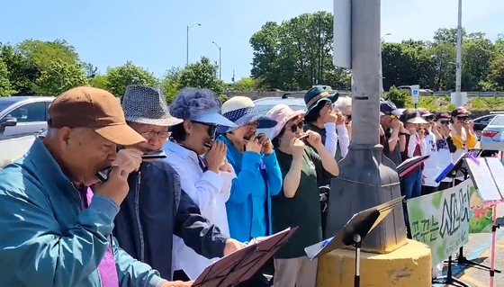 하모니카 연주를 통해 전도 사역을 펼치고 있는 샬롬하모니카선교회(대표 이규석 목사)는 27일 5월의 마지막 푸르른 녹음과 높푸른 하늘 아래 뉴저지주 포트리에 위치한 한남체인 슈퍼마켓 앞에서 전도 찬양 행사를 열었다. 이날 찬양에는 클로스터에 있는 하베스트 시니어스쿨 하모니카 멤버 10명이 참가해 모두 17명이 하모니카 대찬양을 펼쳤다.  [샬롬하모니카선교회]