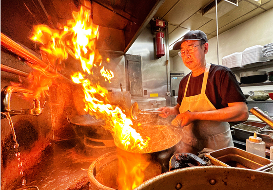 남가주 지역의 기록적인 폭염에도 LA한인타운 올림픽가에 위치한 중국식당 진반점의 하덕현 사장이 뜨거운 불길 속에서 음식을 조리하고 있다.  김상진 기자