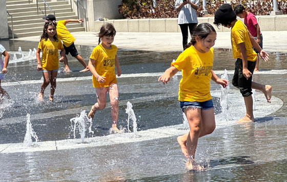 한낮 기온이 화씨 90도를 넘는 불볕더위가 기승을 부린 21일 LA다운타운 그랜드 파크의 분수대에서 어린이들이 물놀이를 즐기고 있다. 김상진 기자