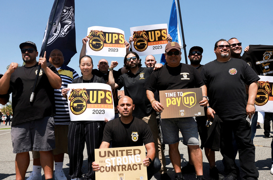 UPS 직원과 팀스터스 노조원들이 오렌지시에서 임금 인상 요구 시위를 벌이고 있다. [로이터]