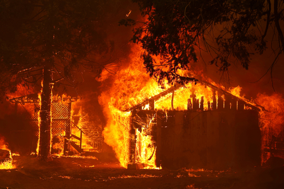 산불 위험 지역 주택들이 다시 주택보험에 가입할 수 있게 된다. 지난 2021년 8월 발생한 딕시 화재로 화염에 휩싸인 그린빌 인근 주택. [로이터]