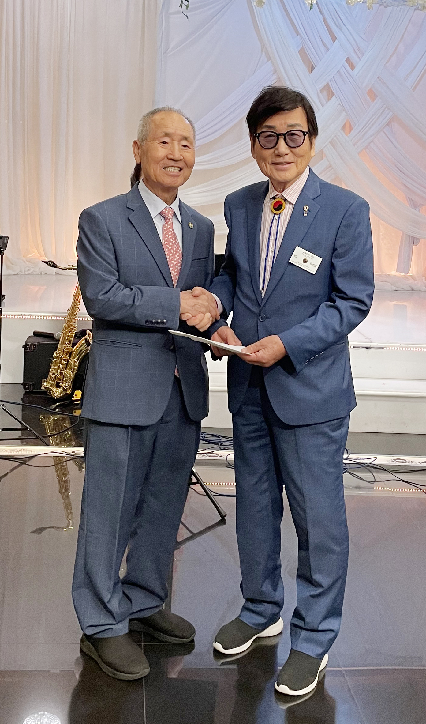 존 하(오른쪽) OC한인라이온스클럽 전 회장이 김가등 노인센터 회장에게 기금을 전달하는 모습.