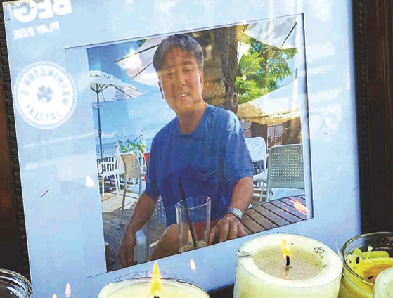 지난 3일 무장강도의 총에 맞아 사망한 업주 찰리 박(60)씨를 애도하는 사진과 촛불이 업소 앞에 놓여 있다. [코모뉴스 캡쳐]