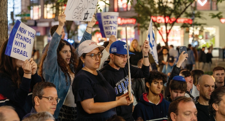 9일 밤 맨해튼 39스트리트 인근 골다메이어스퀘어에서 열린 이스라엘 테러 공격 희생자 추모집회에서 참석자들이 ‘뉴욕은 이스라엘과 함께한다’는 팻말을 들고 있다.  [사진 뉴욕시장실]