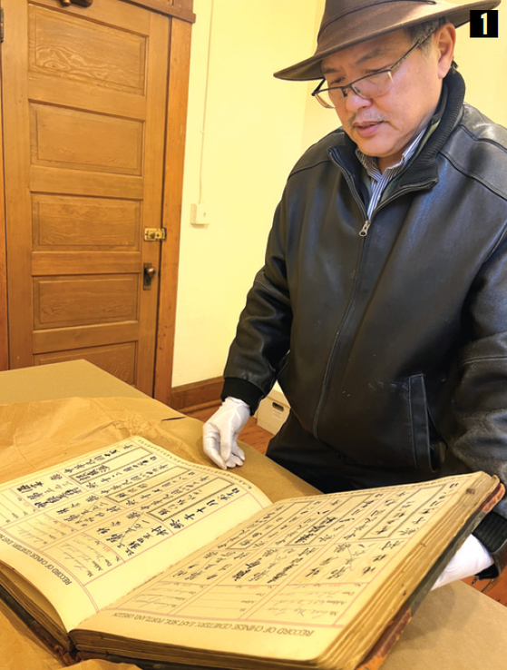 오리건중국인통합자선협회 닐 리 회장이 중국인 이민자 매장 기록 중 한권(1917년 판)을 보여주고 있다.