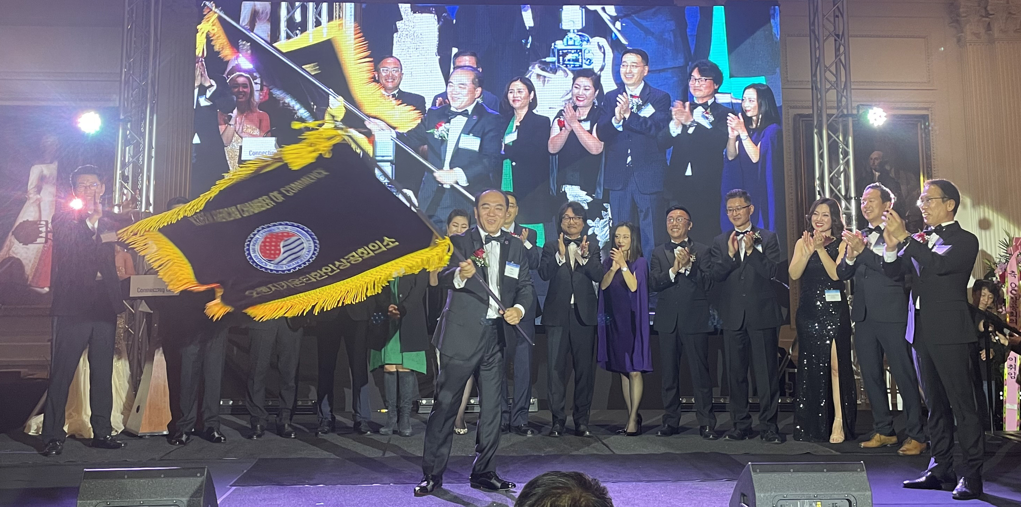 제46대 OC한인상공회의소 짐 구 회장이 임원진의 박수를 받으며 상의 깃발을 흔들고 있다. 맨 오른쪽이 이날 이임한 노상일 45대 회장.
