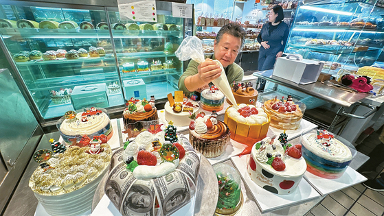 코안도르의 이효상 대표가 크리스마스 케이크 위에 생크림으로 장식하고 있다. 오늘(22일)까지 크리스마스 케이크 구매 예약 시 30% 저렴하게 살 수 있다. 김상진 기자