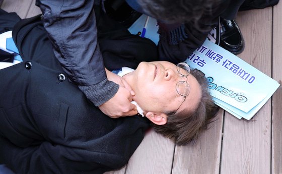 이재명 더불어민주당 대표가 2일 오전 부산 가덕도에서 신원미상인에게 피습을 당한 뒤 쓰러져 있다. 뉴시스