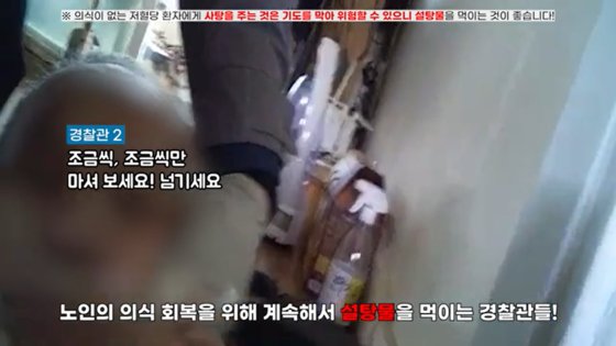 노인에게 설탕물을 먹이고 있는 경찰관들. 사진 대전경찰청 유튜브 캡처 