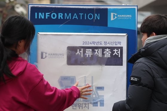 2024 대입 정시모집 원서접수가 시작된 지난 3일 서울 성북구 한성대학교에서 학생들이 접수장소 안내문을 붙이고 있다. 자료사진. 연합뉴스