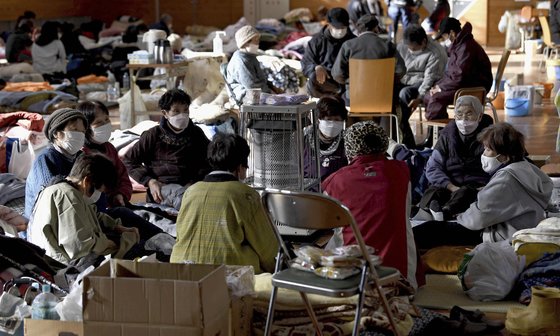 8일 일본 이시카와현 아나미즈마치에서 이재민들이 피난소에서 몸을 녹이고 있다. AP=연합뉴스