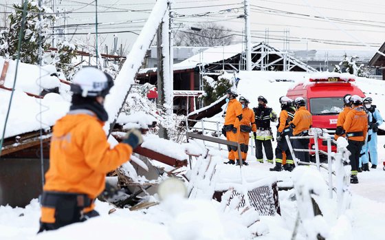 8일 일본 이시카와현 스즈시에서 눈이 오는 가운데 구조대원들이 피해자 구조 작업을 하고 있다. EPA=연합뉴스 