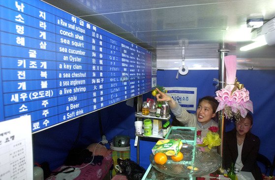 부산 해운대해수욕장 포장마차촌 바다마을 찾은 관광객이 4개국어로 쓰여진 메뉴판을 보며 주문하고 있다. 중앙포토