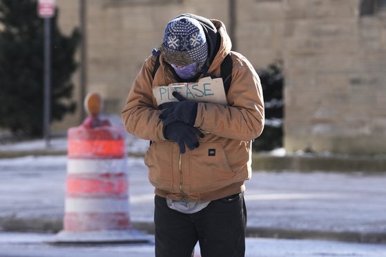 미국 전역에 매서운 한파가 몰아친 가운데 낡은 모자와 장갑, 패딩재킷, 마스크 등으로 무장한 한 사람이 "도와달라"는 팻말을 들고 서 있다. AP=연합뉴스
