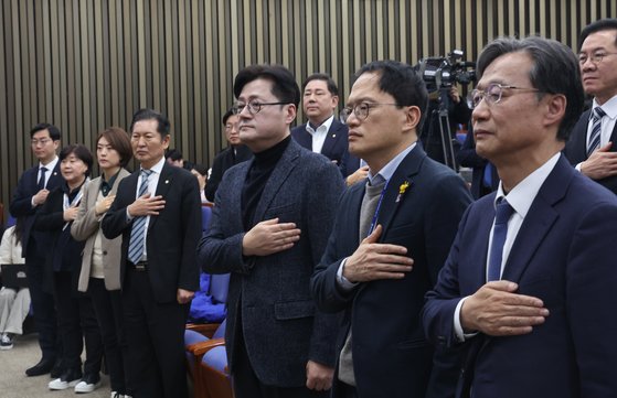 홍익표 더불어민주당 원내대표 등이 25일 서울 여의도 국회에서 열린 의원총회에서 국기에 경례를 하고 있다. 뉴스1