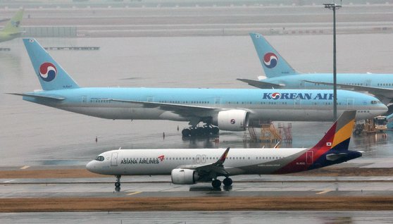 인천국제공항 계류장에 세워진 대한항공 항공기 앞으로 아시아나 항공기가 지나가고 있다.   뉴스1