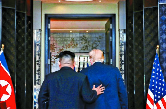 김정은 북한 국무위원장(왼쪽)과 도널드 트럼프 미국 대통령이 2018년 6월 12일(현지시간) 싱가포르의 카펠라 호텔에서 북·미 정상회담 공동성명 문서에 서명을 마치고 이동하고 있다. 신화사
