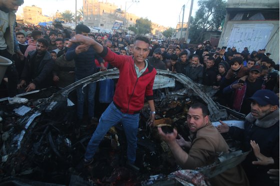 7일(현지시간) 팔레스타인 가자지구 남부 도시 라파에서 현지 주민들이 이스라엘군의 공스븡로 파괴된 차량에 모여 있다. 신화=연합뉴스