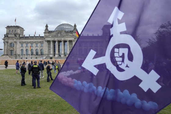 지난 12일(현지시간) 독일 베를린의 연방의회 건물 밖에서 트랜스젠더 커뮤니티의 권리를 보호하기 위한 법률을 요구하는 시위자들이 깃발을 들고 있다. 이날 독일 의원들은 트랜스젠더, 인터섹스, 논바이너리가 공식 기록에서 자신의 성별을 더 쉽게 바꿀 수 있도록 하는 법안을 승인했다. AP=연합뉴스