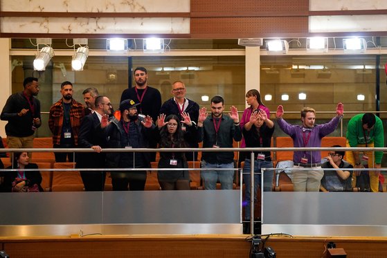 지난해 12월 스페인 마드리드 지역 의회에서 트랜스젠더에 대한 보호를 철회하는 제안을 통과시키려는 투표에서 LGBTQ+ 활동가들이 '피 묻은 손'이라는 뜻으로 빨간 손을 들어보이고 있다. 로이터=연합뉴스