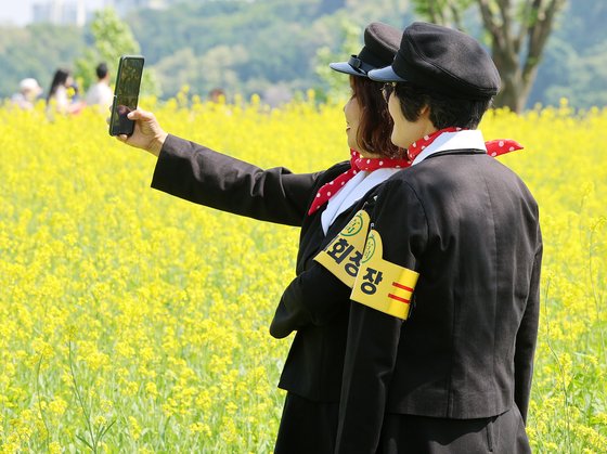 구리 유채꽃축제가 열린 지난 10일, 경기 구리 한강시민공원을 찾은 시민들이 옛 교복을 입고 노랗게 핀 유채꽃을 배경으로 사진을 찍고 있다. 뉴스1