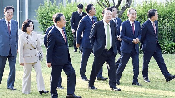 윤석열 대통령이 지난 13일 서울 용산구 한남동 관저에서 열린 국민의힘 비대위원 만찬에 앞서 참석자들과 정원을 산책하고 있다. 사진 대통령실