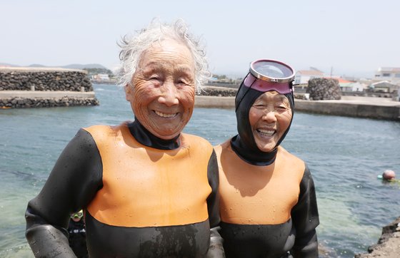 지난 25일 오후 제주시 한림읍 귀덕2리 포구에서 92살 김유생(왼쪽) 해녀와 91살 강두교 해녀가 은퇴식에 앞서 마지막 물질을 마치고 나서 환하게 웃고 있다. 연합뉴스