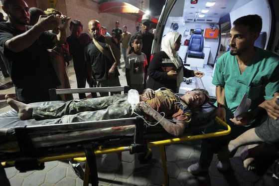 26일(현지시간) 이스라엘의 폭격으로 부상당한 팔레스타인인이 가자 지구 중심부 데이르 알 발라에 있는 알 아크사 병원으로 이송되고 있다. AP=연합뉴스