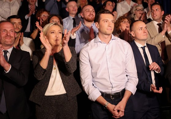 지난 24일 프랑스 북부에서 열린 극우정당 국민연합(RN)의 유럽의회 선거 캠페인 회의에서 마린 르펜(왼쪽에서 두번째)이 유력 후보인 조르당 바르델라 대표(왼쪽에서 세번째) 옆에 서서 박수를 보내고 있다. AFP=연합뉴스
