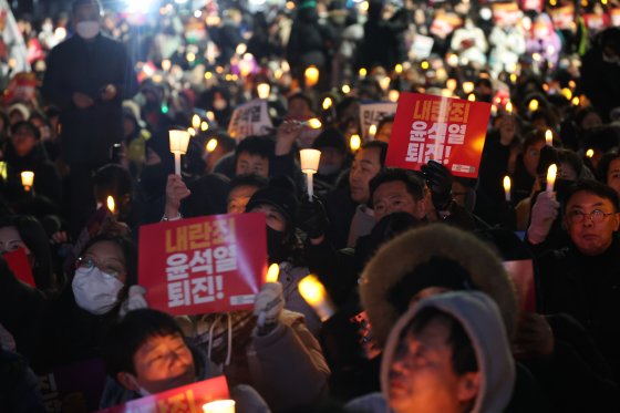 6일 오후 서울 여의도 국회의사당 앞에서 열린 윤석열 대통령의 퇴진 촉구 집회에서 시민들이 촛불과 손피켓을 들고 정권 퇴진을 촉구하고 있다. 뉴스1