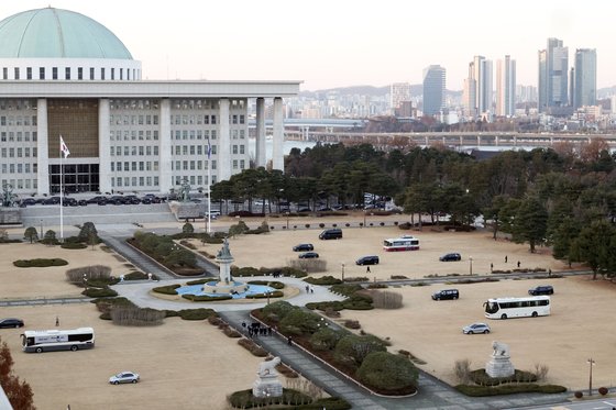 2차 비상계엄에 대비해 16일 국회 잔디광장에 계엄군의 헬기 착륙을 방지하려는 목적으로 대형 버스와 국회 사무처 관계자들의 차량이 배치돼 있다. 김성룡 기자