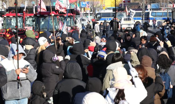 전국농민회총연맹 전봉준 투쟁단이 윤석열 대통령 구속 등을 촉구하며 트랙터 상경 시위에 나섰다가 서울 서초구 남태령에서 20시간 이상 대치를 이어간 22일 서울 서초구 남태령 인근에서 시민들이 구호를 외치고 있다. 연합뉴스