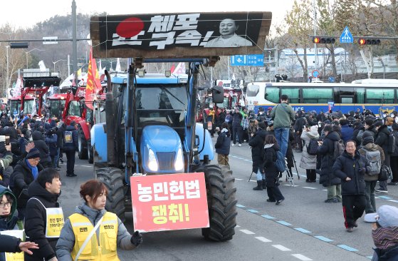 서울 서초구 남태평 고개에서 가로 막았던 전국농민회총연맹(전농) 소속 트랙터들이 22일 오후 4시쯤 경찰이 차벽을 해제하면서 서울 한남동 대통령 관저 방향으로 행진하고 있다. 연합뉴스.