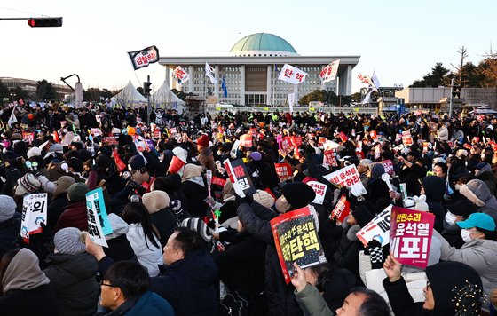 윤석열 대통령 탄핵안 표결이 진행된 지난 14일 오후 서울 여의도 국회의사당 인근에서 시민들이 집회를 하고 있다. 김종호 기자