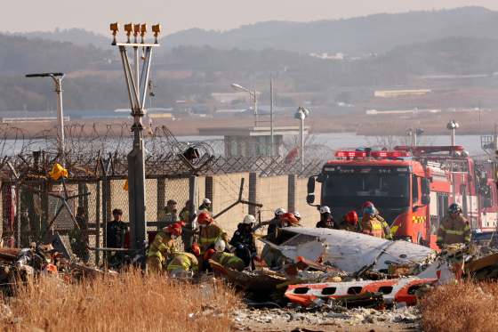 119구조대원들이 사고 여객기 잔해를 수습하고 있다. [뉴스1]