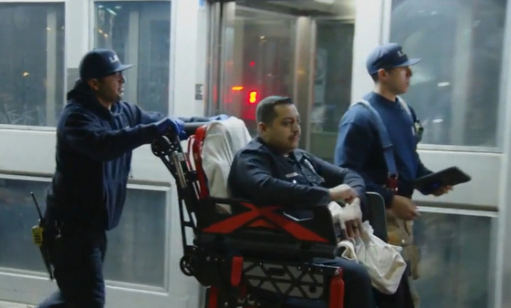 LAPD 경찰관이 휠체어에 실려나오고 있다. [FOX11 스크린 캡쳐]