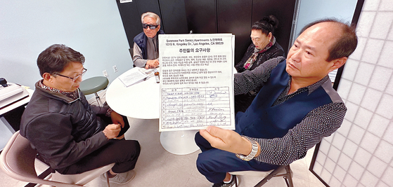 18일 주민의회 찾은 스완시 파크 시니어 아파트에 거주하는 피해자들이 입주민들의 서명이 담긴 ‘주민들의 요구사항’을 설명하고 있다. 김상진 기자