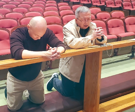 앤드루 서(왼쪽)씨가 출소 직후인 지난 26일 그레이스교회 본당에서 양아버지인 김한철 장로와 함께 기도를 하고 있다. [김한철씨 제공]