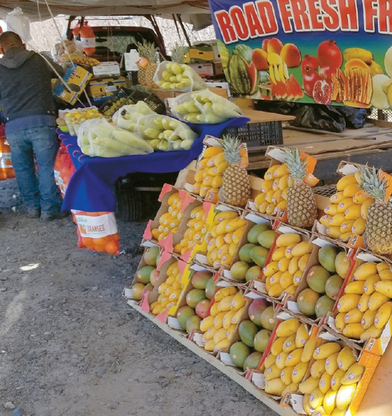 현지 생산된 싱싱한 과일과 채소를 판매하는 길거리 상인.