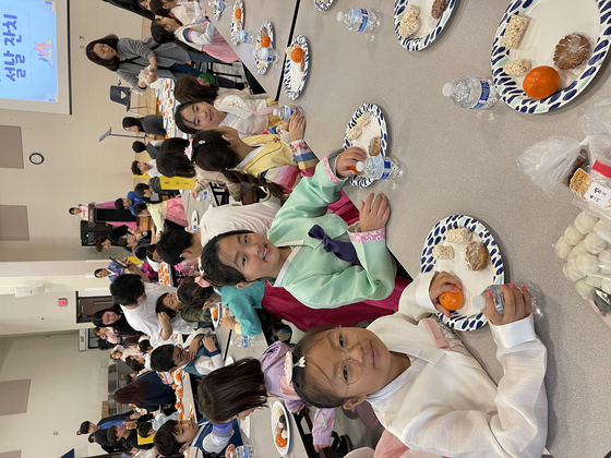 학생들이 모여 떡과 과일을 먹고 있다.
