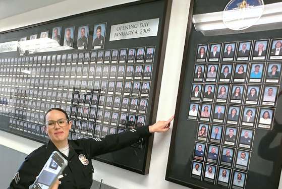 15주년을 맞은 지난 5일 찾아간 올림픽경찰서의 다이애나 리들 SLO 수퍼바이저가 2009년 설립 당시 근무했던 경찰관들의 사진을 보여주고 있다.  김상진 기자