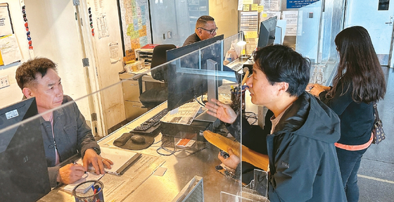통역봉사자 황기윤(왼쪽)씨가 1일 오전 올림픽 경찰서를 찾은 한인의 사건 접수를 돕고 있다.  김상진 기자