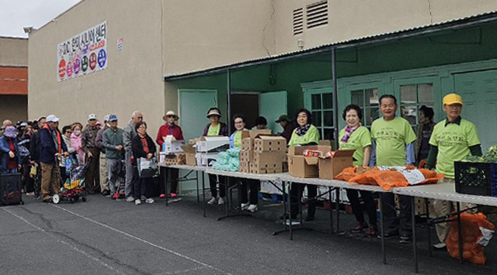 OC한미시니어센터 관계자들이 23일 센터 주차장에서 다양한 식품을 무료로 나눠주고 있다. [센터 제공] 