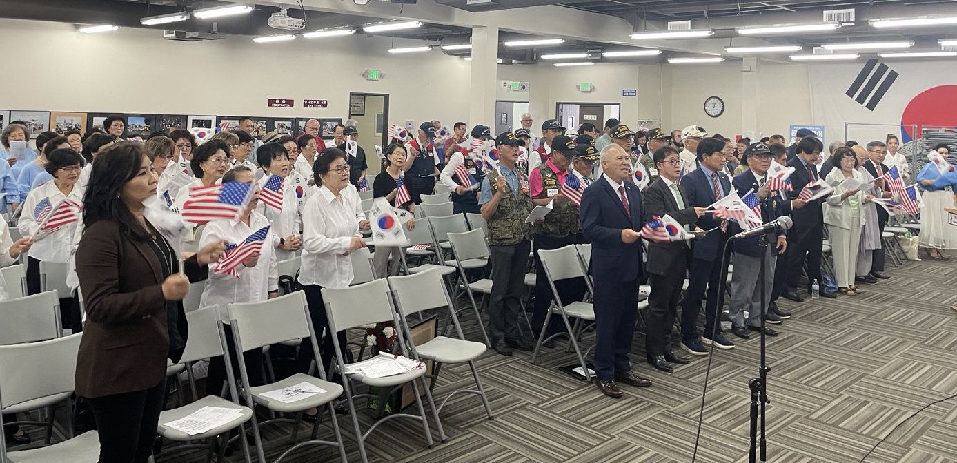 OC한인회 주최 광복절 기념식 참석자들이 태극기와 성조기를 흔들며 광복절 노래를 제창하고 있다.