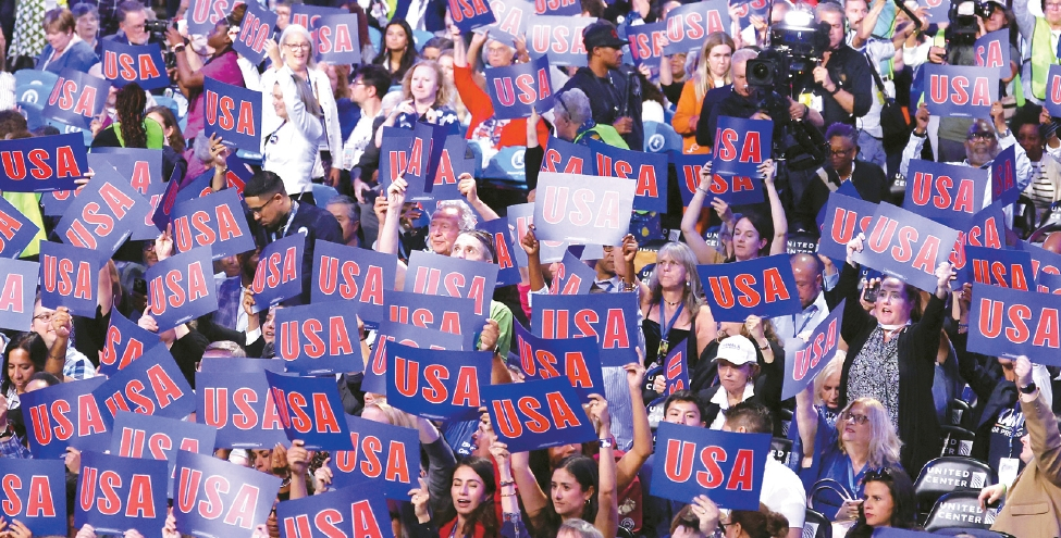 19일 민주당 전당대회가 시카고 유나이티드 센터에서 개막했다. 개막식에 참석한 민주당원들이 ‘USA’가 적힌 피켓을 들고 환호하고 있다.  [로이터]