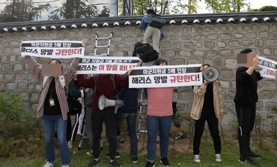 한국대학생진보연합 소속 대학생이 2019년 10월 18일 오후 서울 중구 주한 미국대사관저에서 방위비분담금 협상 관련 기습 농성을 하기 위해 담벼락을 넘고 있다. [중앙포토]