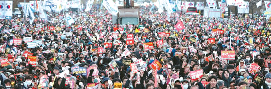 윤석열 대통령 탄핵소추안이 가결된 14일(한국 시간) 서울 여의도 국회 앞에서 열린 탄핵 촉구 집회에 참석한 시민들이 환호하고 있다. [연합뉴스]